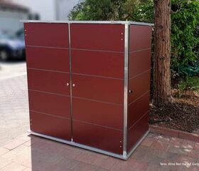 . Roter Gartenschrank auf einer Terrasse neben einem Baum, vermutlich zur Aufbewahrung im Freien.