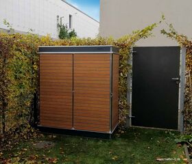 . Ein orange-brauner Gartenschrank steht neben einer dunklen Tür, umgeben von Laubhecken und einem Gebäude im Hintergrund.