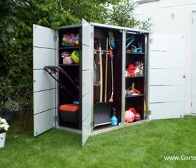 . Ein geöffneter Gartenschrank mit verschiedenen Spiel- und Gartengeräten, darunter ein Rasenmäher und Bälle.