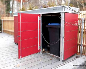 . Roter Gartenschrank mit offener Tür, eine Mülltonne innen. Pflanzendekoration auf dem Dach.