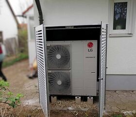 Ein Außengerät einer Wärmepumpe von LG, in einem Gehäuse neben einem Gebäude installiert.