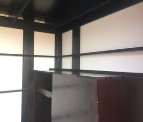 Ein minimalistischer Raum mit dunklen Holzverkleidungen und weißen Paneelen.