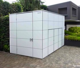Ein moderner, rechteckiger Gartenschuppen mit weißer Verkleidung, neben einem Haus und Garten.