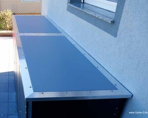 Metallische Gartenbox an einer Hauswand.