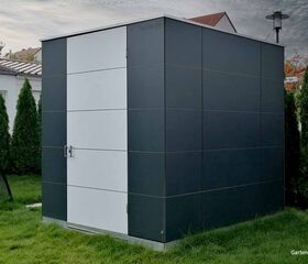 . Ein modernes Gartenhaus mit grauen und weißen Paneelen, umgeben von Bäumen.