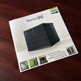 Ein Prospekt auf einem Tisch mit einem modernen Gartenhaus auf dem Cover.