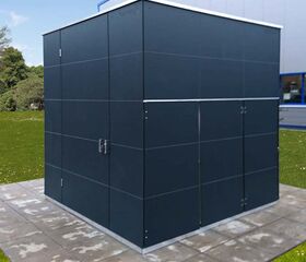 Ein moderner, quadratischer Schuppen steht auf betonierten Platten in einem grünen Gartenbereich vor einem Gebäude.