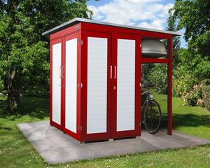 Ein rotes Gartenhaus mit weißen Türen, auf einer Terrasse, neben einem Fahrrad und einem grünen Garten.
