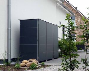 . Ein modern gestalteter Garten mit großem, grauem Schrank, umgeben von Pflanzen und einem gepflasterten Boden.