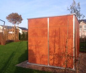 . Ein Garten mit Rasen, Bäumen und einer kleinen modernen Holzhütte.