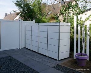 Weiße Schränke neben einem lila Blumentopf draußen, umgeben von Bäumen und Zäunen.