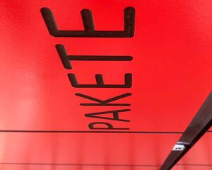 Rote Paketbox mit dem Wort "PAKETE" darauf.