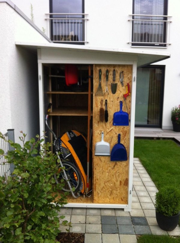 . Ein Gartenschuppen mit Werkzeugen und einem Rasenmäher.